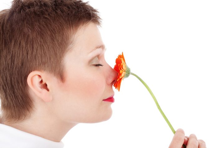 kobieta wąchająca kwiatek